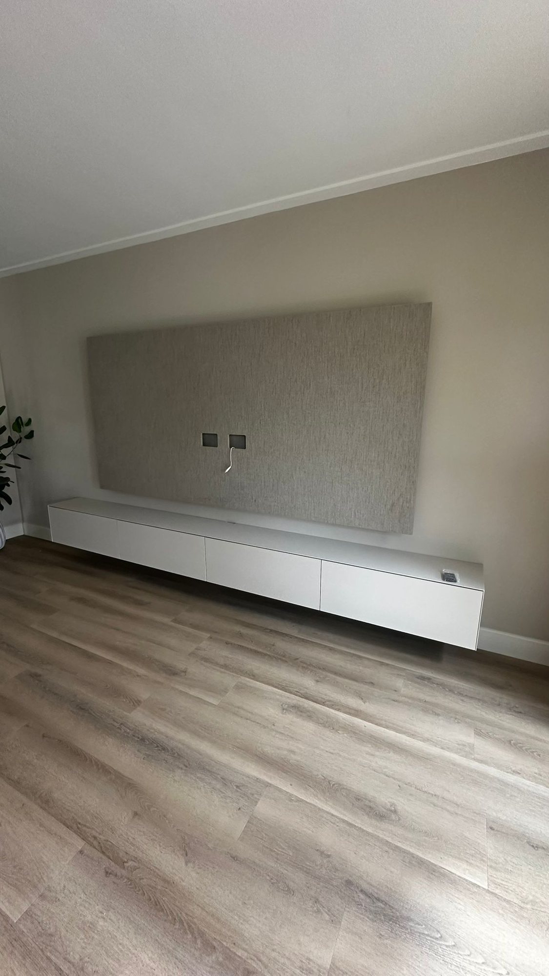 Grijs textiel-look paneel boven een wit meubel